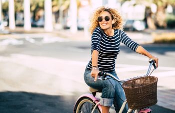 Cheerful energetic middle-aged woman riding a bike